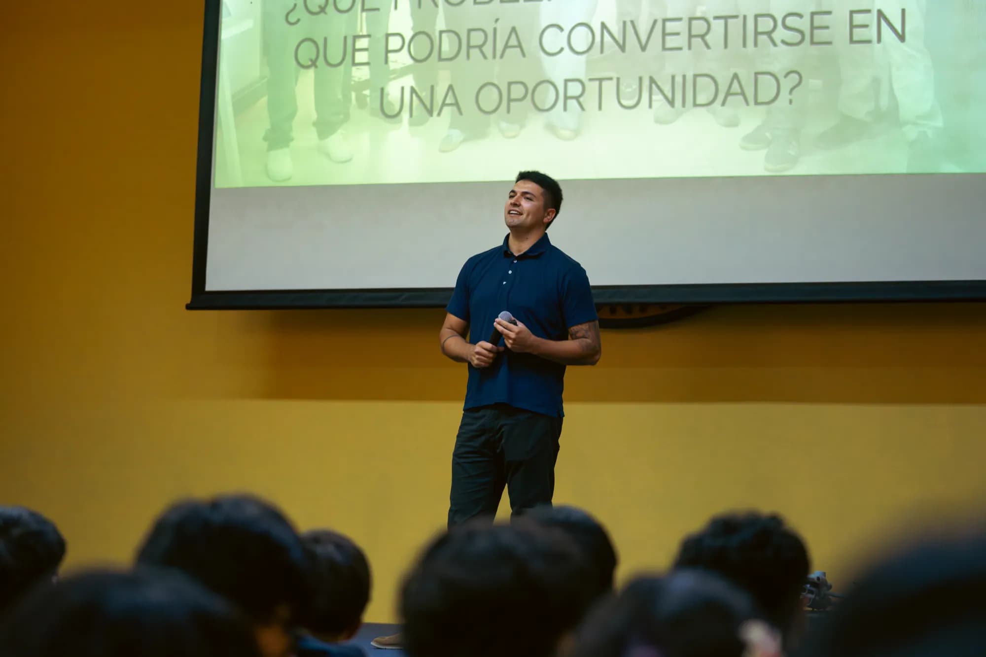 Christian Cubelli, de AGS, exponiendo sobre el escenario del auditorio del colegio AIS frente a los asistentes