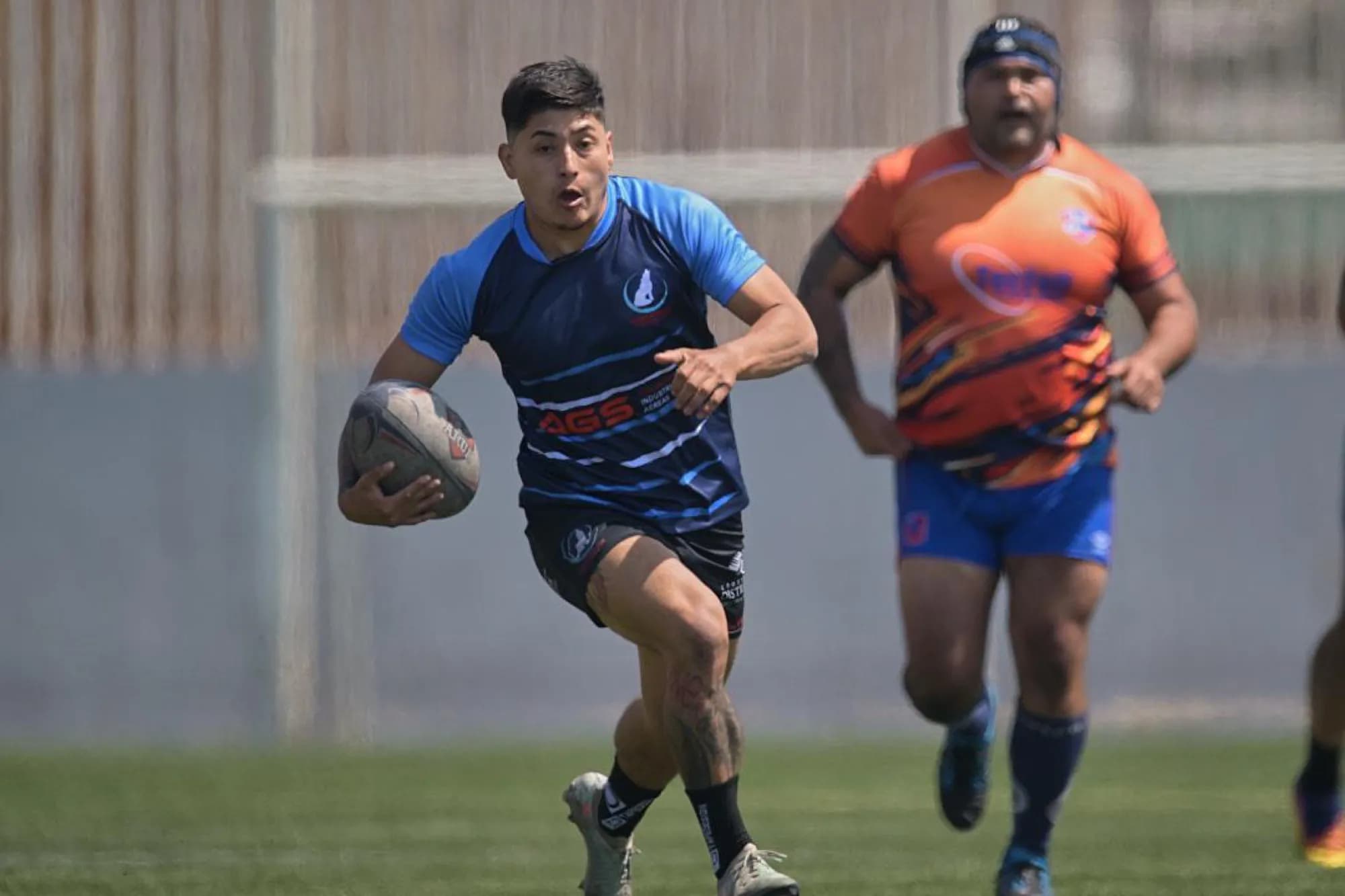 Un jugador de Coyotes Antofagasta corre con el balón durante un partido, con la camiseta auspiciada por AGS