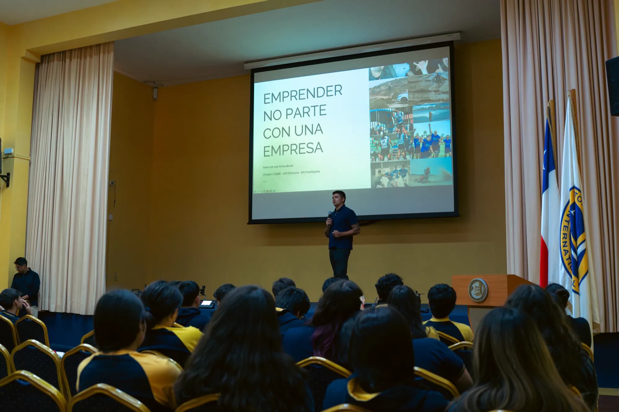Vista general del auditorio durante la charla, con la diapositiva 'Emprender no parte con una empresa' proyectada en pantalla